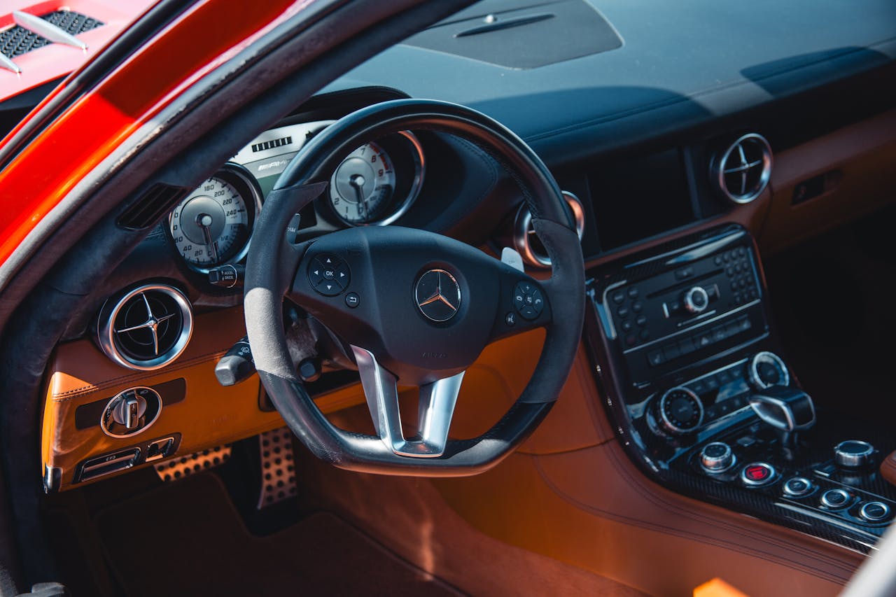 Close-up of a luxury car's dashboard and steering wheel showcasing design and elegance.